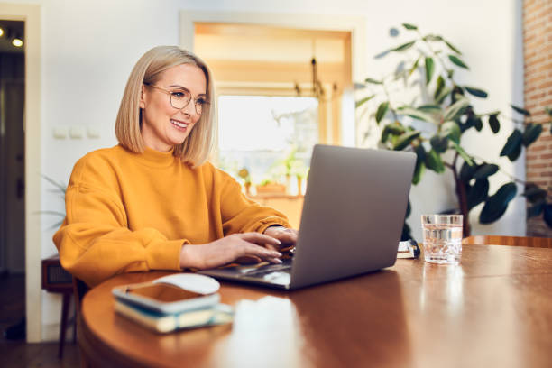 Woman sat at her desk working on laptop.